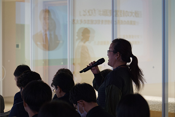 会場でマイクを持ち質問する人