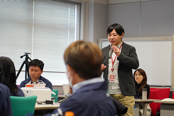 マイクを持ち話している人と周りで話を聞く人たち